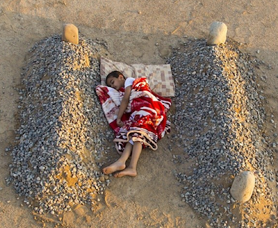 enfant dort entre la tombe de son pere et de sa mere