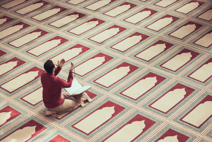 Un homme invoque Allah dans une mosquée